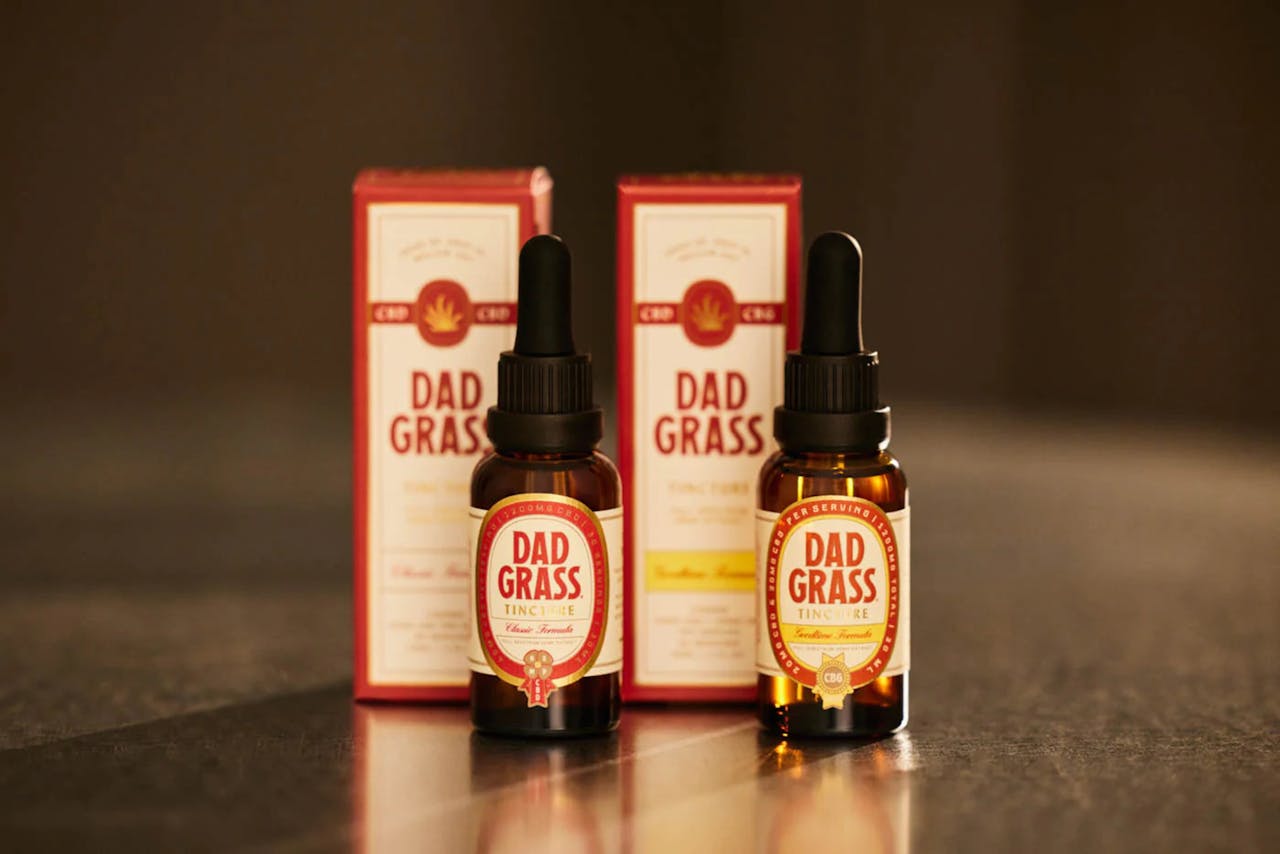 Close-up view of Dad Grass CBD oil tincture bottles and packaging, ideal for wellness branding.