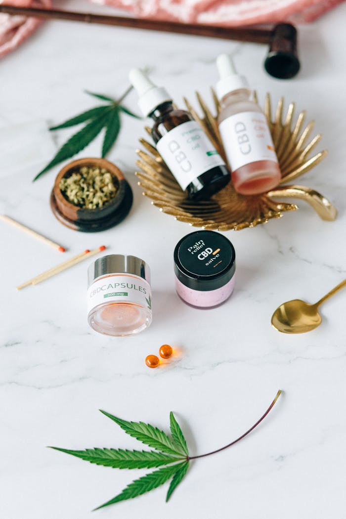 Flat lay of CBD products including oils and capsules next to hemp leaves.